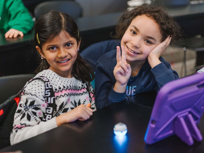 2 kids in a classroom smiling